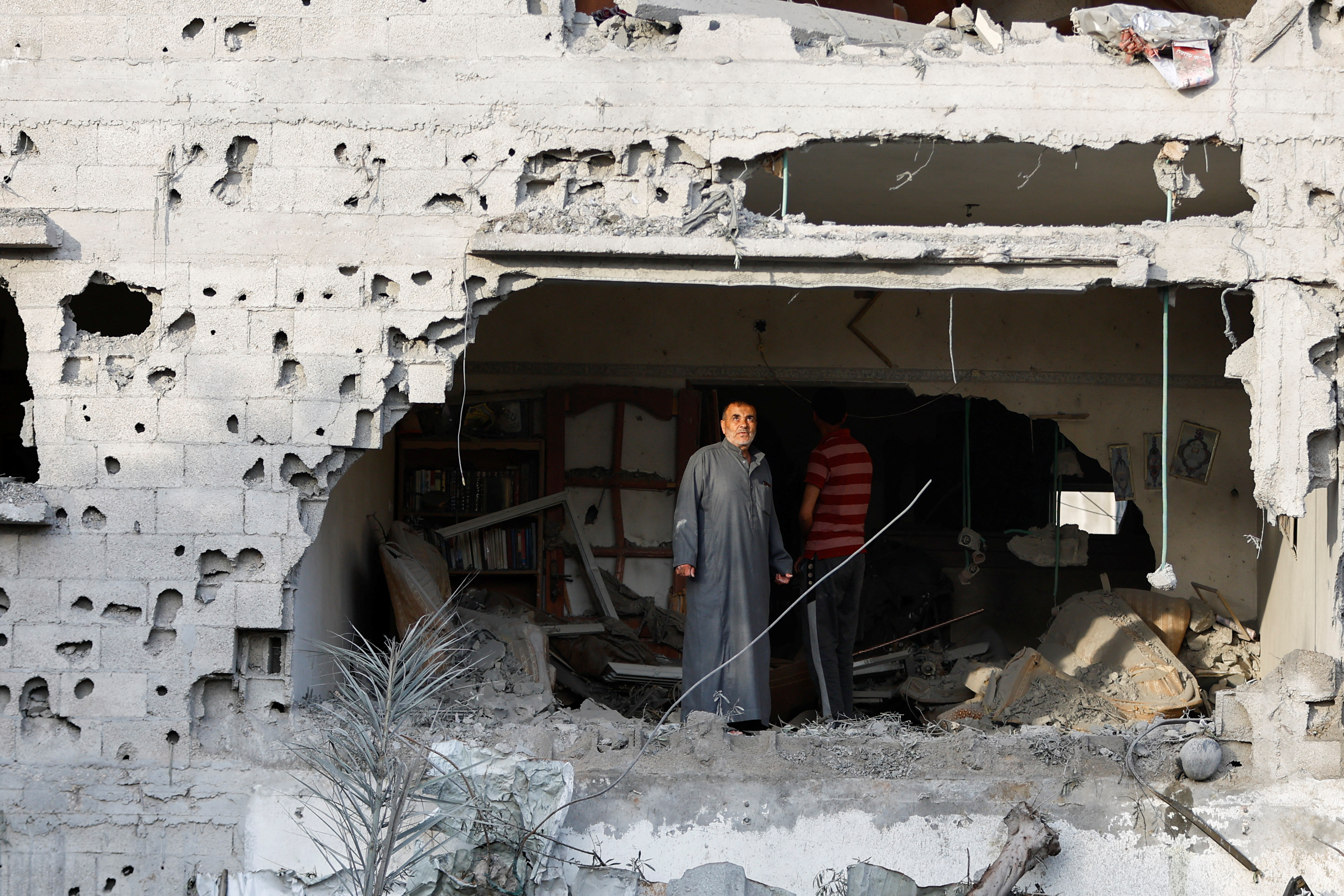 Palestinians gather at the site of an Israeli airstrike amid Israel-Gaza fighting in Deir al-Balah town