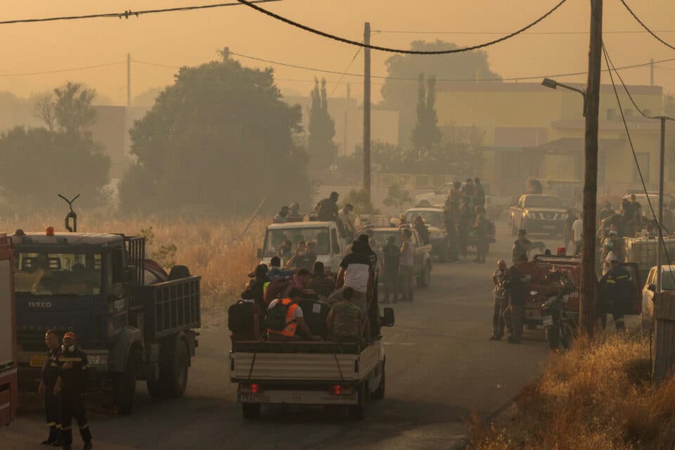 Locals prepare to tackle a wildfire approaching the village of Masari in Rhodes, Greece, July 24, 2023. REUTERS/Nicolas Economou