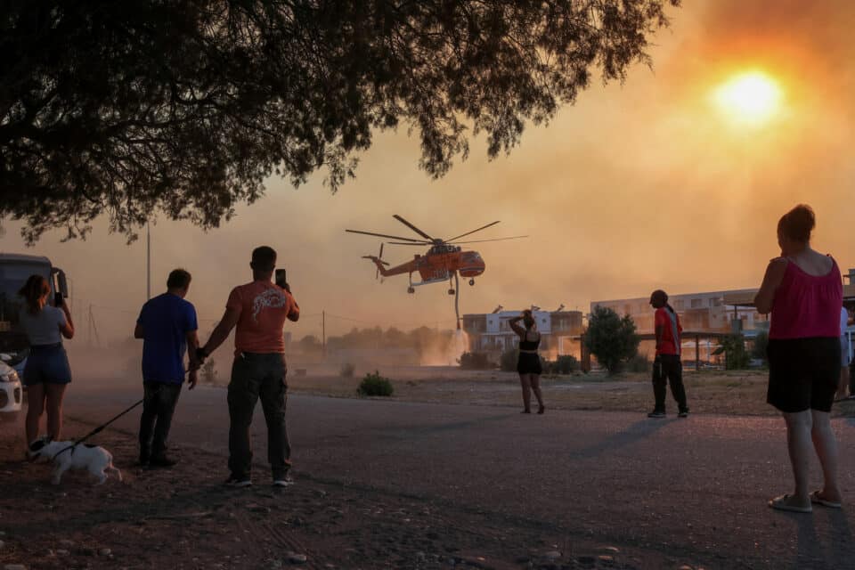 A helicopter filling water from a pool in the village of Gennadi, in Rhodes, Greece, July 25, 2023. REUTERS/Nicolas Economou   