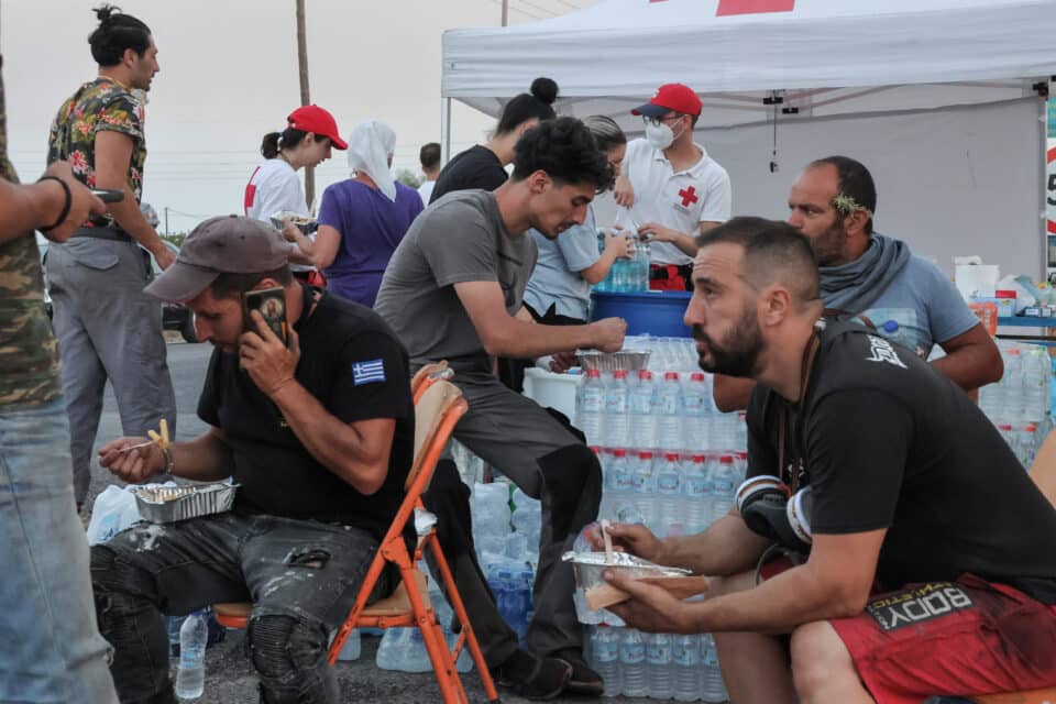 Volunteers rest at a gathering point as a wildfire burns in the village of Gennadi, on the island of Rhodes, Greece, July 26, 2023. REUTERS/Nicolas Economou