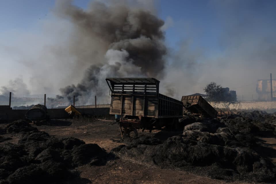 Destroyed truck carriages are seen in a factory yard as a wildfire burns at the city of Volos, in central Greece, July 27, 2023. REUTERS/Alexandros Avramidis