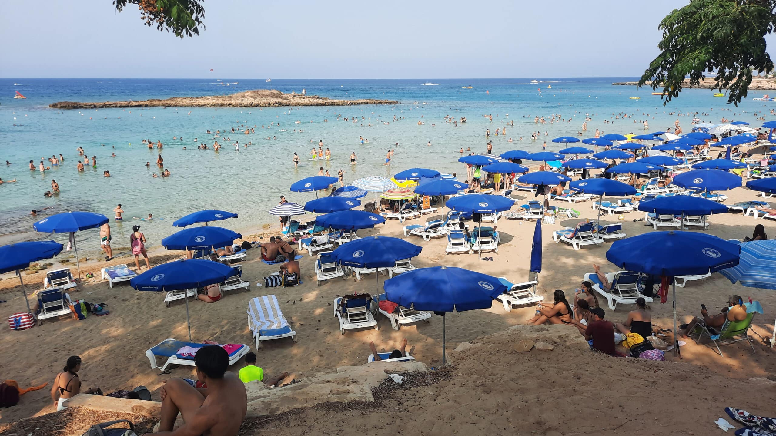 feature nick a few lone private umbrellas among a sea of paid for sunbeds and blue umbrellas