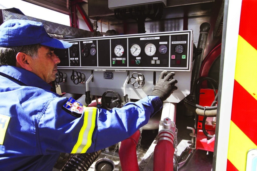 feature jon a firefighter adjust the water pressure on one of the hoses (christos theodorides)